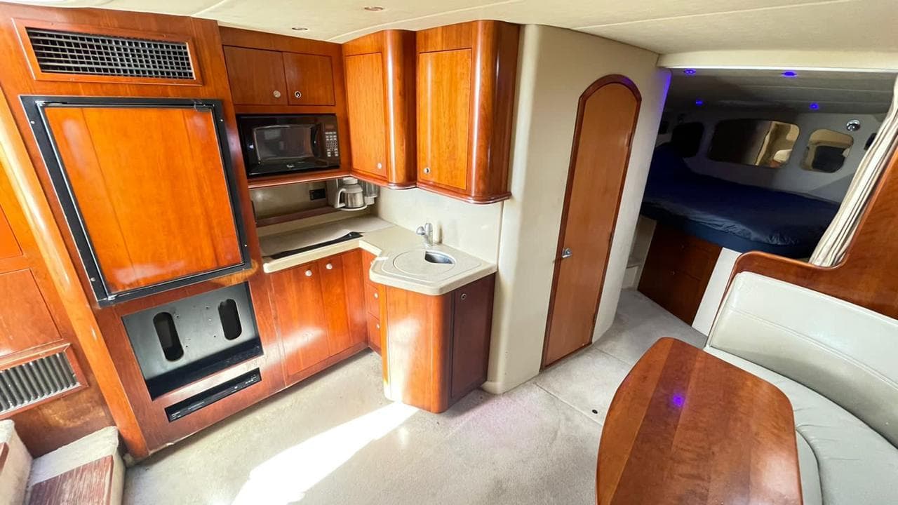 Kitchen with microwave, wooden furniture and countertop.
