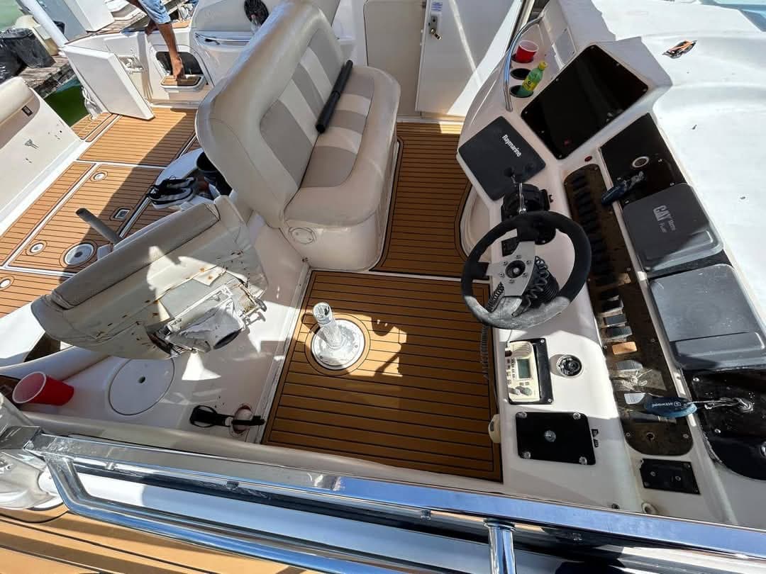 Command station with steering wheel, screen, and captain's seat.