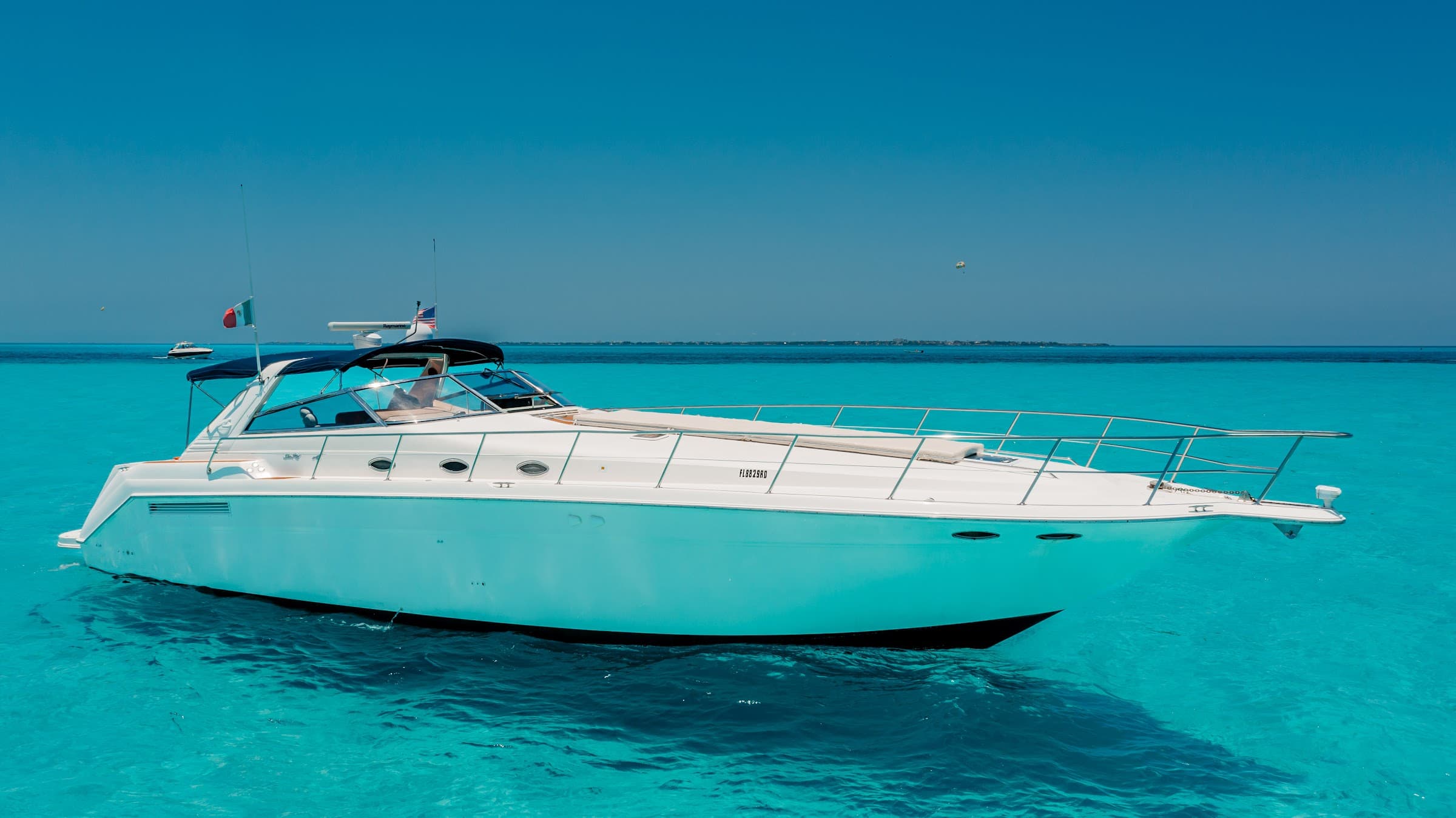 Full profile of the yacht over clear turquoise water.