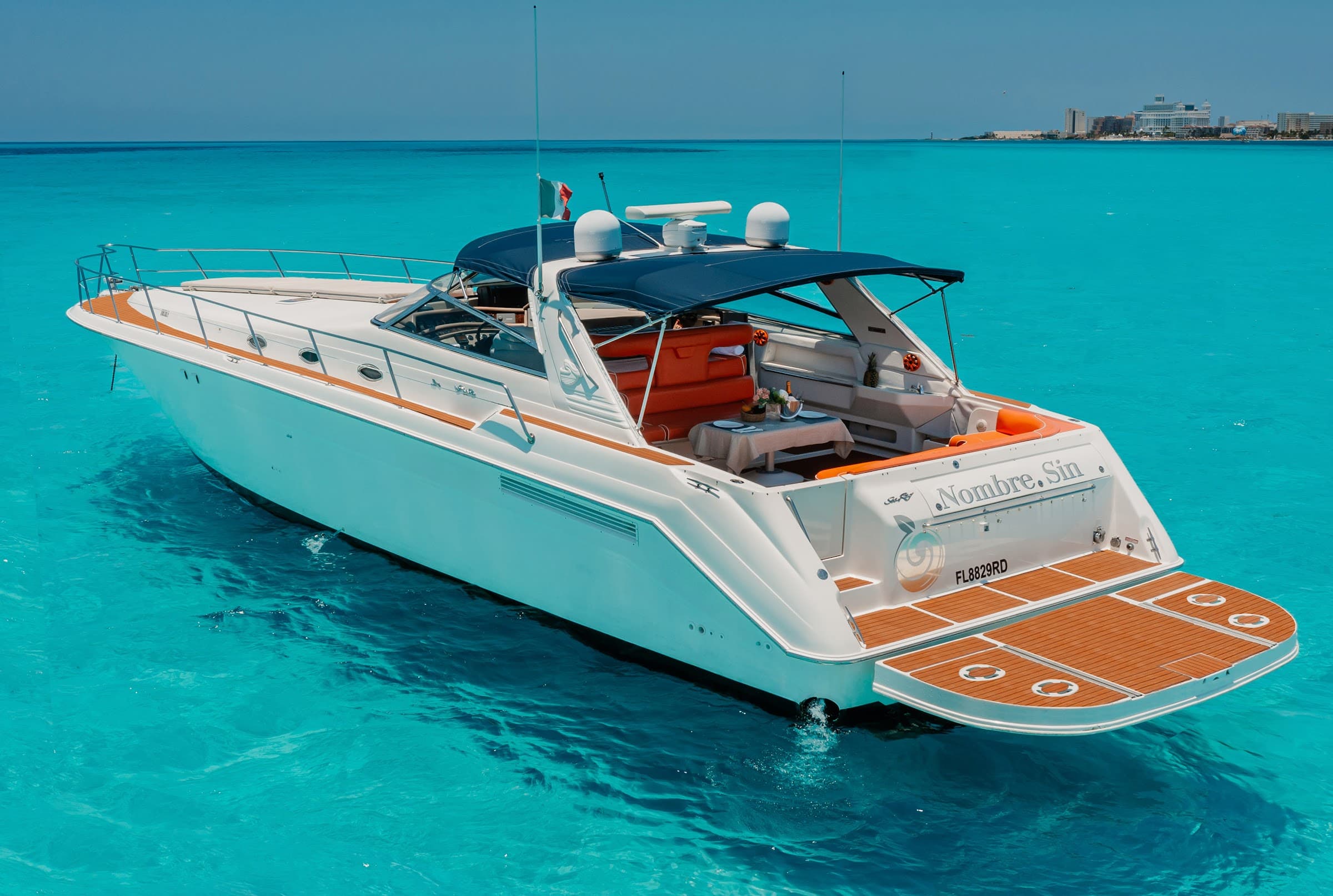 The yacht seen from the stern, anchored in turquoise water.