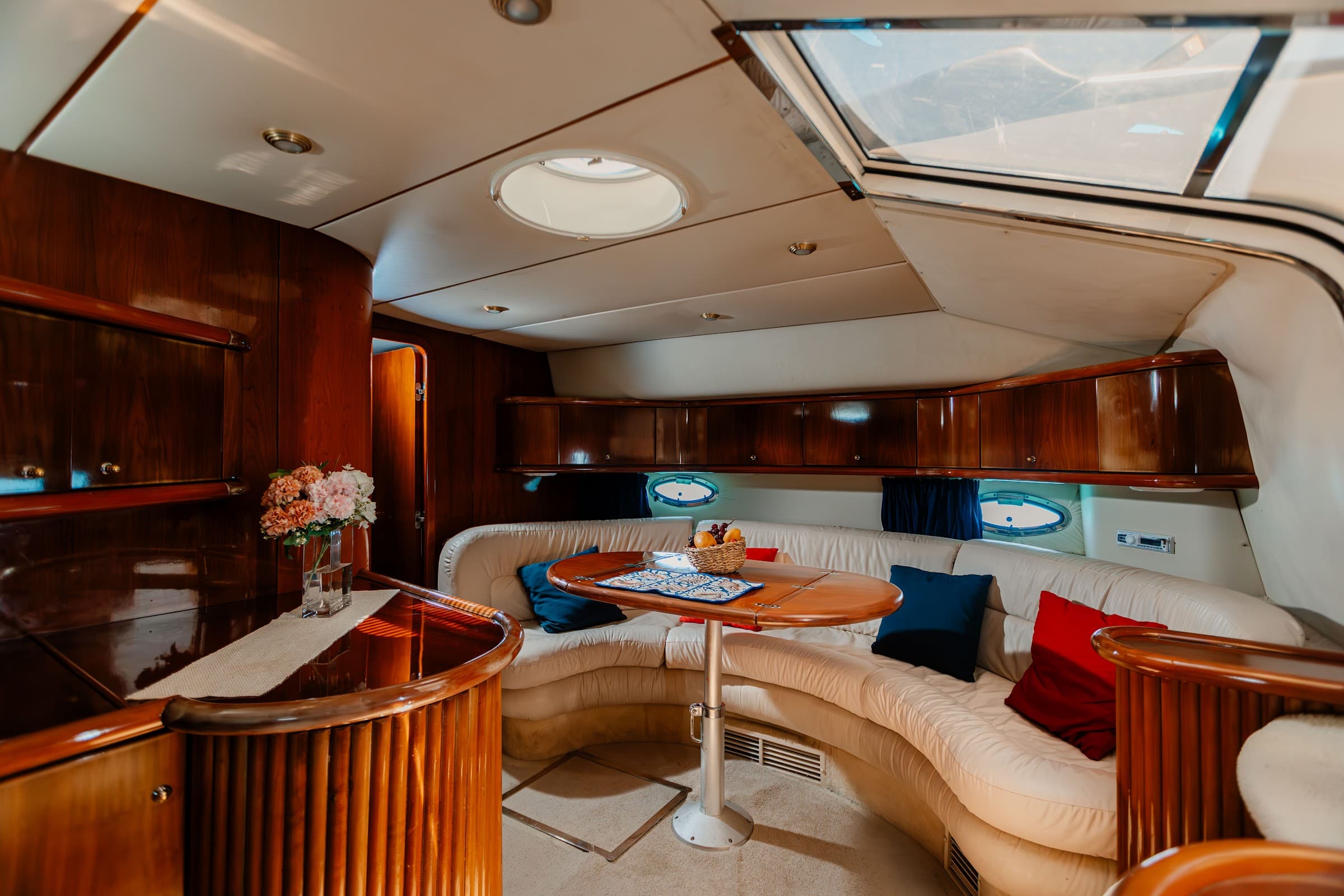 Indoor dining room with curved sofa, round table, and skylight.