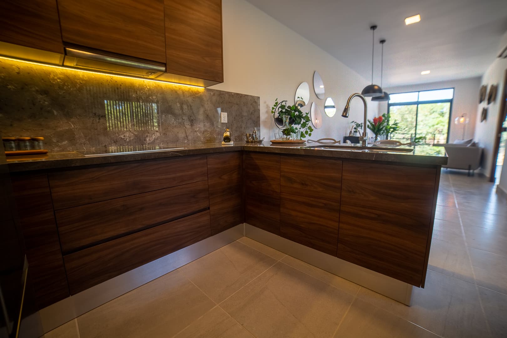 L-shaped kitchen with wooden countertop and light-colored cabinets.