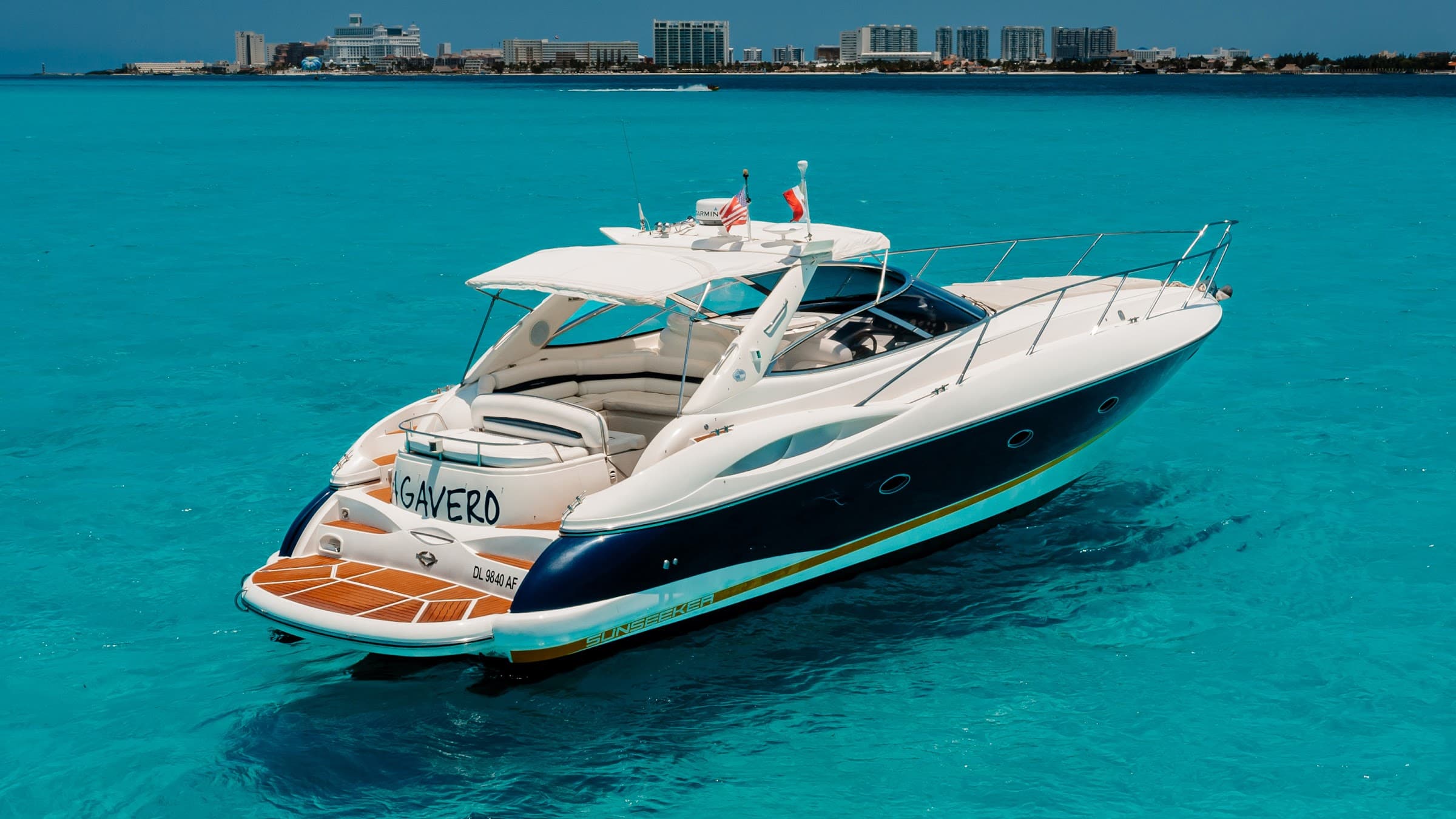 A view of the yacht from the water, with the coast on the horizon.