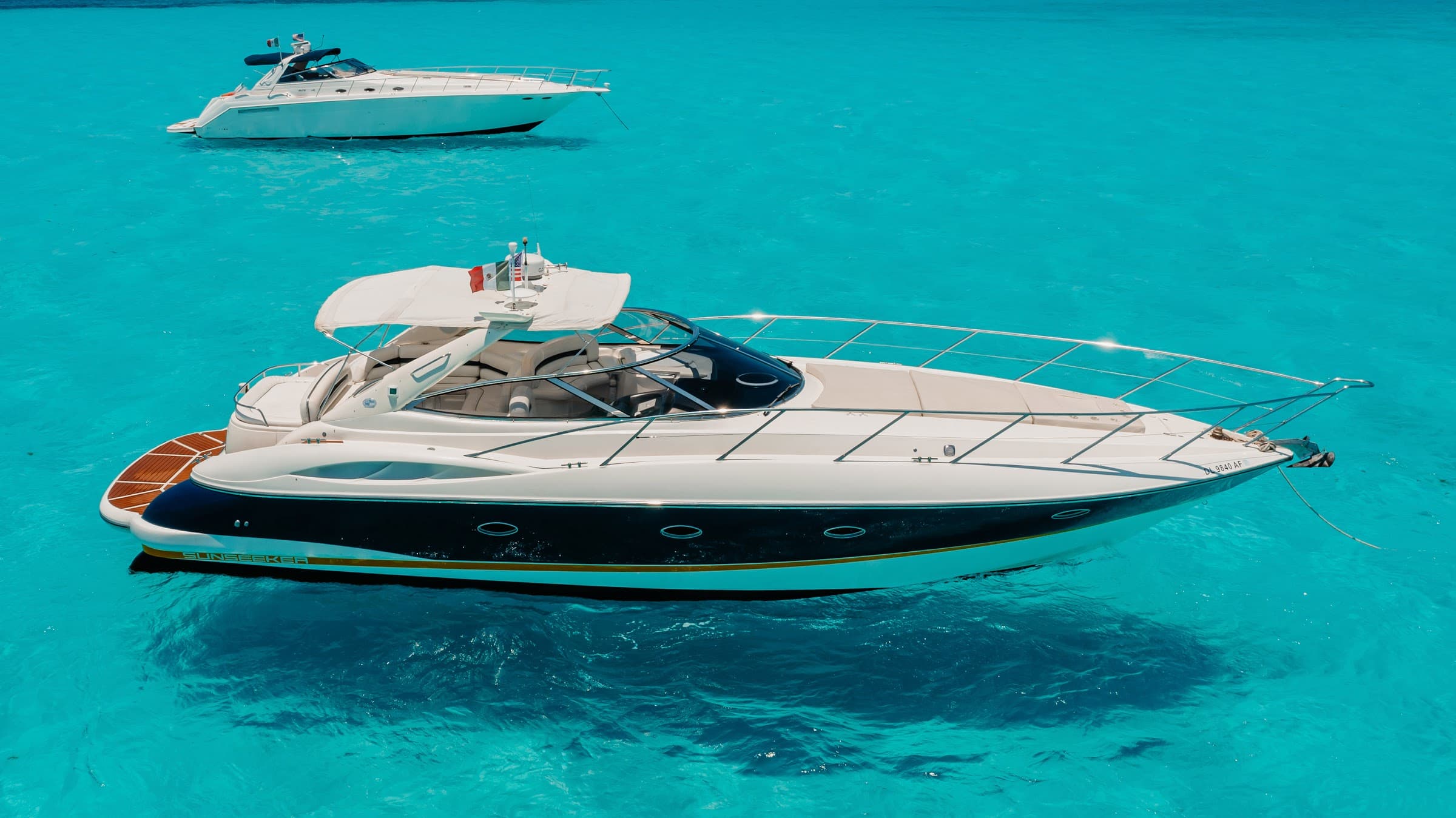 The yacht viewed from the bow over clear turquoise water.