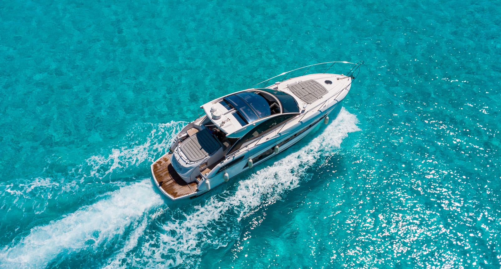 The yacht sailing, seen from the air, leaving a wake.